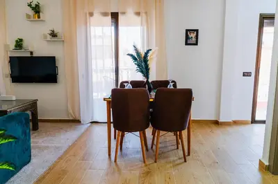 a living room with a table with chairs and a television at Appartement Moderne à Marrakech in Marrakech