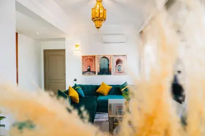 a living room with a green couch with yellow pillows at Appartement Moderne à Marrakech in Marrakech