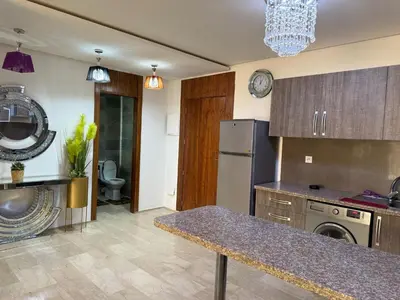 a kitchen with a counter top and a refrigerator at Appartemen luxe in Marrakech