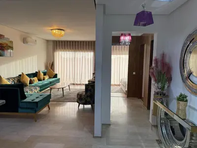 a living room with a green couch and a living room at Appartemen luxe in Marrakech