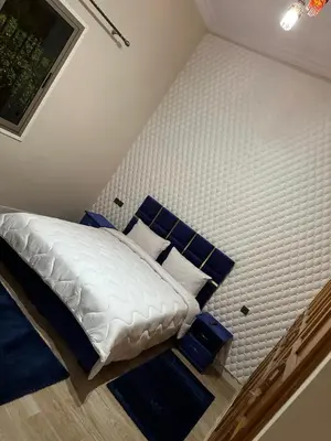 a bedroom with a white bed with blue pillows at Villa haut standig 2000 m2 in Marrakech