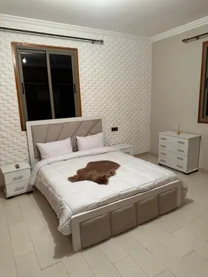 a white bedroom with a large bed with a brown animal on it at Villa haut standig 2000 m2 in Marrakech