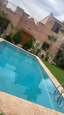 a large blue swimming pool in front of a building at Villa haut standig 2000 m2 in Marrakech