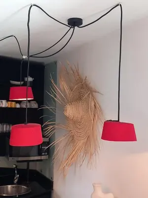 two red lights hanging from a wall with a plant at Cosy et confortable in Marrakech