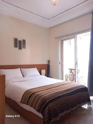a bedroom with a large bed and a large window at Cosy et confortable in Marrakech