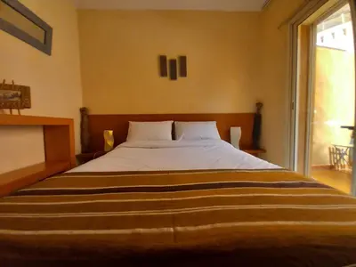 a large bed in a room with a large window at Cosy et confortable in Marrakech