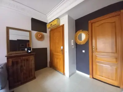 a hallway with a wooden door and a mirror at Cosy et confortable in Marrakech