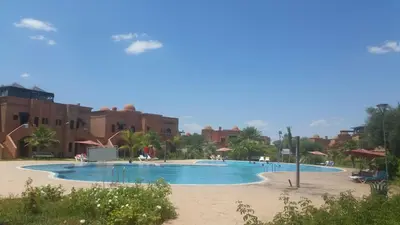 a large swimming pool in a resort with buildings at Atlas resort, 3 pools, roof terrace, holiday home in Marrakech