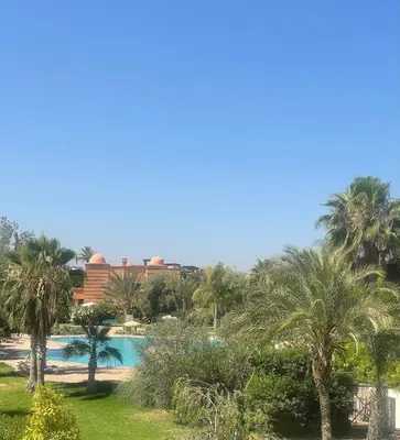 a view of a resort with palm trees and a swimming pool at Atlas resort, 3 pools, roof terrace, holiday home in Marrakech