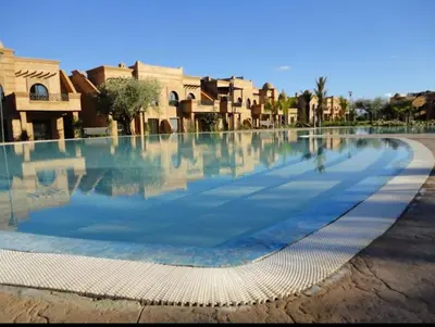a large pool of water with buildings in the background at Atlas resort, 3 pools, roof terrace, holiday home in Marrakech