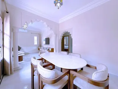 a dining room with a white table and chairs at New! Duplex Annakhil , Calme et proximité centre in Marrakech