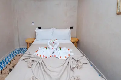 a bed with white sheets with cherries on it at Riad Akkioui in Marrakech