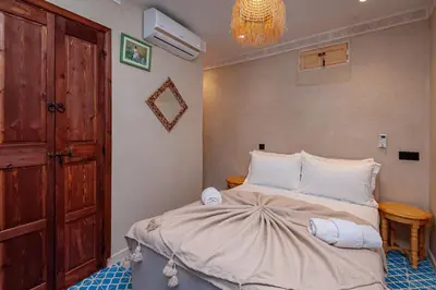 a bedroom with a bed with white pillows at Riad Akkioui in Marrakech