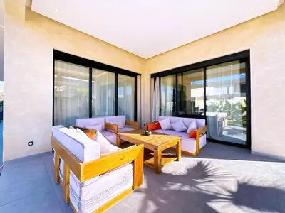 a living room with furniture and large windows at villa Emna Design Contemporain & piscine chauffée in Marrakech