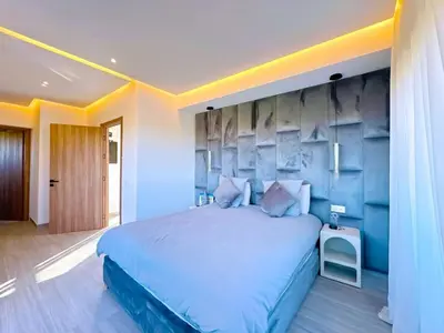 a bedroom with a large bed with a blue wall at villa Emna Design Contemporain & piscine chauffée in Marrakech