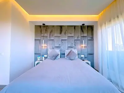 a bedroom with a large white bed with two pillows at villa Emna Design Contemporain & piscine chauffée in Marrakech