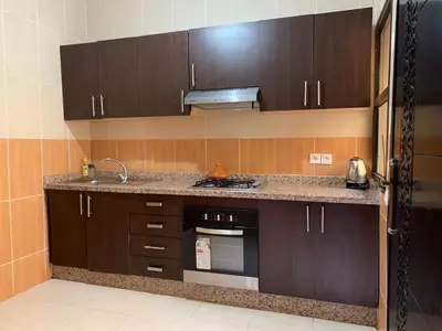 a kitchen with brown cabinets and a stove top oven at chic&Calm appartment in gueliz in Marrakech