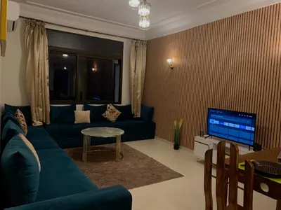 a living room with a blue couch and a television at chic&Calm appartment in gueliz in Marrakech