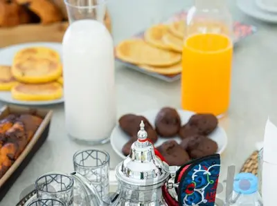 a table with plates of breakfast foods and orange juice at Modern Villa Assia in Marrakech