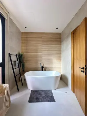 a bathroom with a white tub and a wooden door at Modern Villa Assia in Marrakech