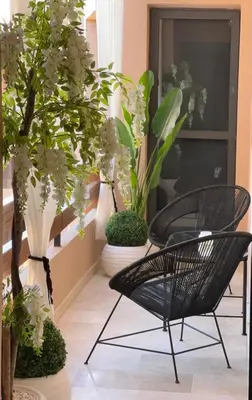 a patio with a black chair and some plants at Prestige cocon in Marrakech