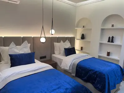 two beds in a bedroom with blue and white at Prestige Cocon in Marrakech