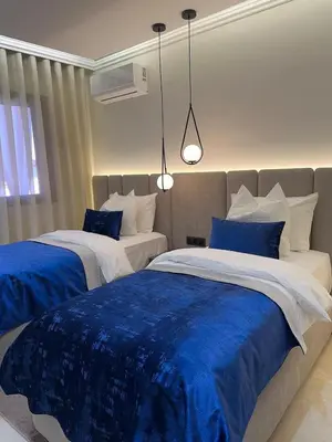 a bedroom with two beds with blue and white sheets at Prestige Cocon in Marrakech