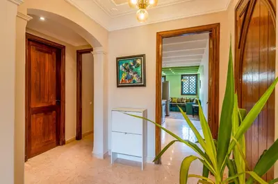 a living room with a potted plant and a hallway at Cozy Stay with Garden & Pool, 10min to Center in Marrakech