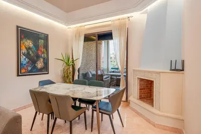 a dining room with a table and chairs and a fireplace at Cozy Stay with Garden & Pool, 10min to Center in Marrakech