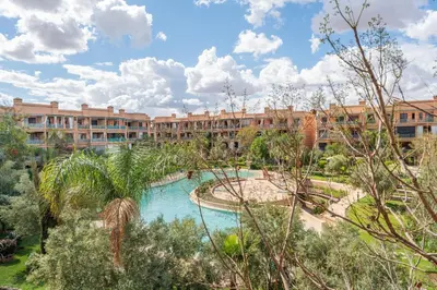 a view of a resort with a pool and trees at Cozy Stay with Garden & Pool, 10min to Center in Marrakech