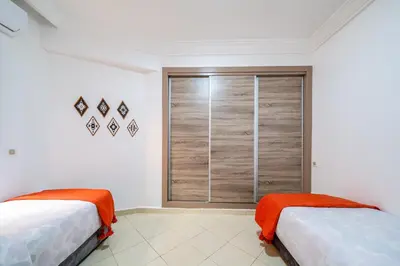 two beds in a room with a window at Appartement Luxe à Marrakech in Marrakech