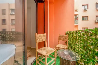 two chairs and a glass table on a balcony at Appartement Luxe à Marrakech in Marrakech