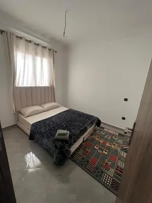 a bedroom with a bed and a rug on the floor at Modern Apartment in Great Location of Marrakesh in Marrakech