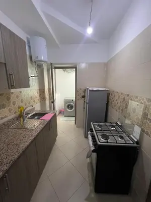 a small kitchen with a stove and a refrigerator at Modern Apartment in Great Location of Marrakesh in Marrakech