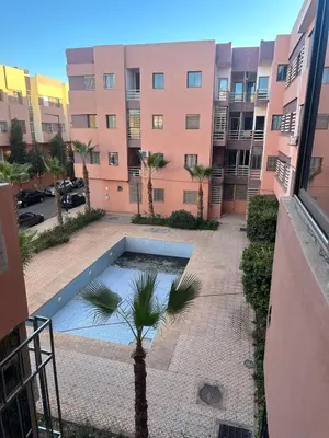 a courtyard with a palm tree in front of a building at Modern Apartment in Great Location of Marrakesh in Marrakech