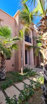 a house with palm trees in front of it at Villa marrakech in Marrakech