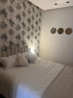 a bedroom with a large white bed with wallpaper at cozy apartment in Marrakesh in Marrakech