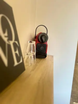 a red speaker sitting on a table next to a glass at cozy apartment in Marrakesh in Marrakech
