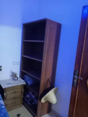 a bedroom with a wooden book shelf next to a bed at Passenger house in Marrakech