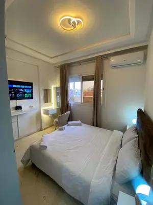 a bedroom with a large bed and a window at Homesweethome in Marrakech