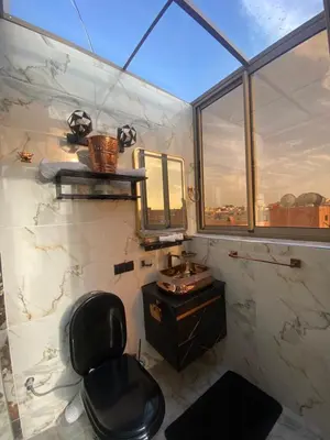 a bathroom with a black chair and a mirror at Homesweethome in Marrakech