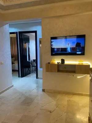 a living room with a flat screen tv on a wall at Homesweethome in Marrakech