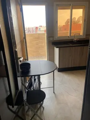 a small kitchen with a table and a window at Homesweethome in Marrakech