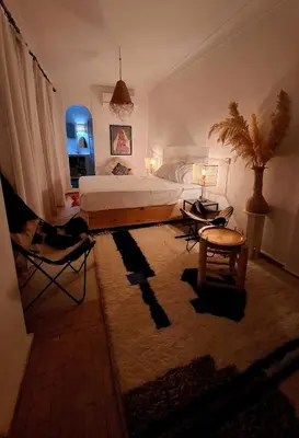 a bedroom with a bed and a table and chairs at Riad Dar el Hachmia - Central private Riad, Air cond, heated pool and Hammam in Marrakech