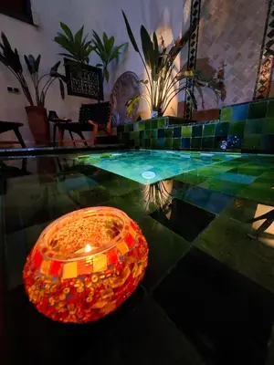 a glass table with a candle in the middle of a pool at Riad Dar el Hachmia - Central private Riad, Air cond, heated pool and Hammam in Marrakech