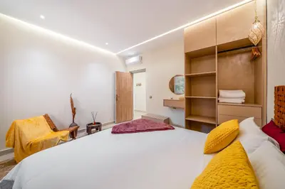 a bedroom with a large white bed with yellow pillows at Lux & comfort Sunny terrace in Gueliz in Marrakech