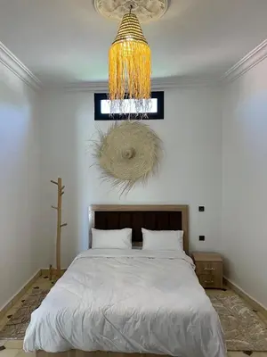 a bedroom with a bed and a chandelier at Villa Familiale avec Piscine Privée à Marrakech in Marrakech