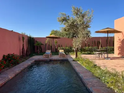 a pool with two chairs and umbrellas in a yard at Villa Familiale avec Piscine Privée à Marrakech in Marrakech