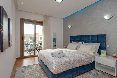 a bedroom with a large bed with a blue headboard at pearl garden in Marrakech