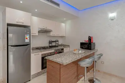 a kitchen with white cabinets and a stainless steel refrigerator at pearl garden in Marrakech